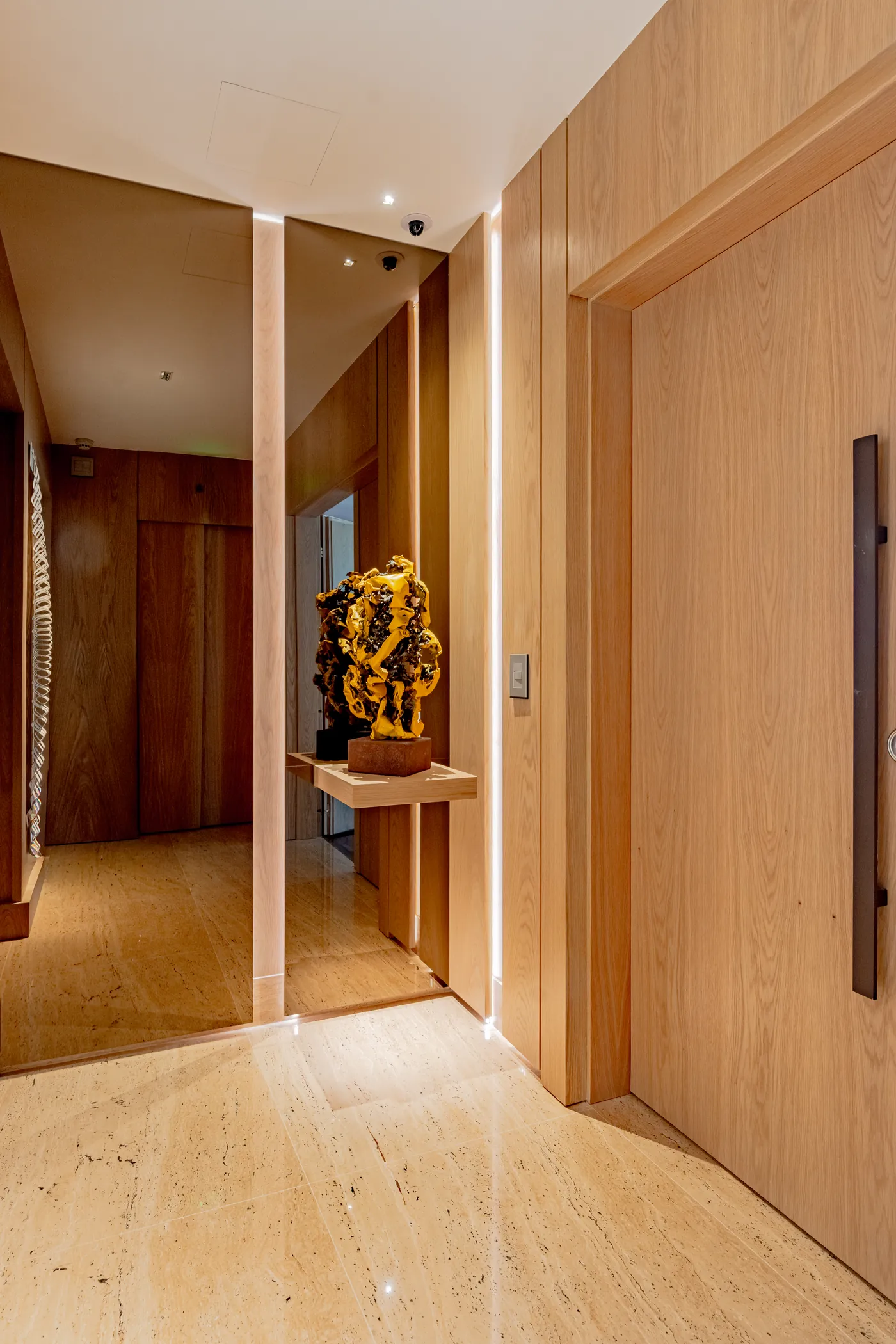 Hall do apartamento com travertino e madeira clara